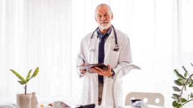 Senior doctor with smartwatch in office.