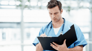 Male doctor with stethoscope writing patient's report