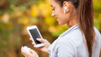 Runner listening to MCAT Go by MedSchoolCoach. Fitness, sport and healthy lifestyle concept - smiling runner with earphones