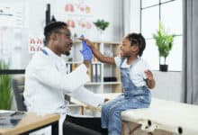student doctor high fiving a pediatric patient during residency