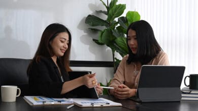 Two women sitting down discussing how to pay for and finance medical school.